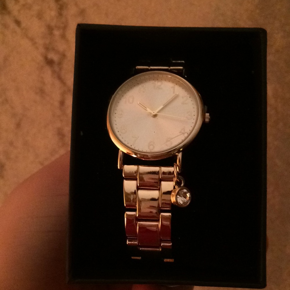 Claire’s gold watch with diamond charm.